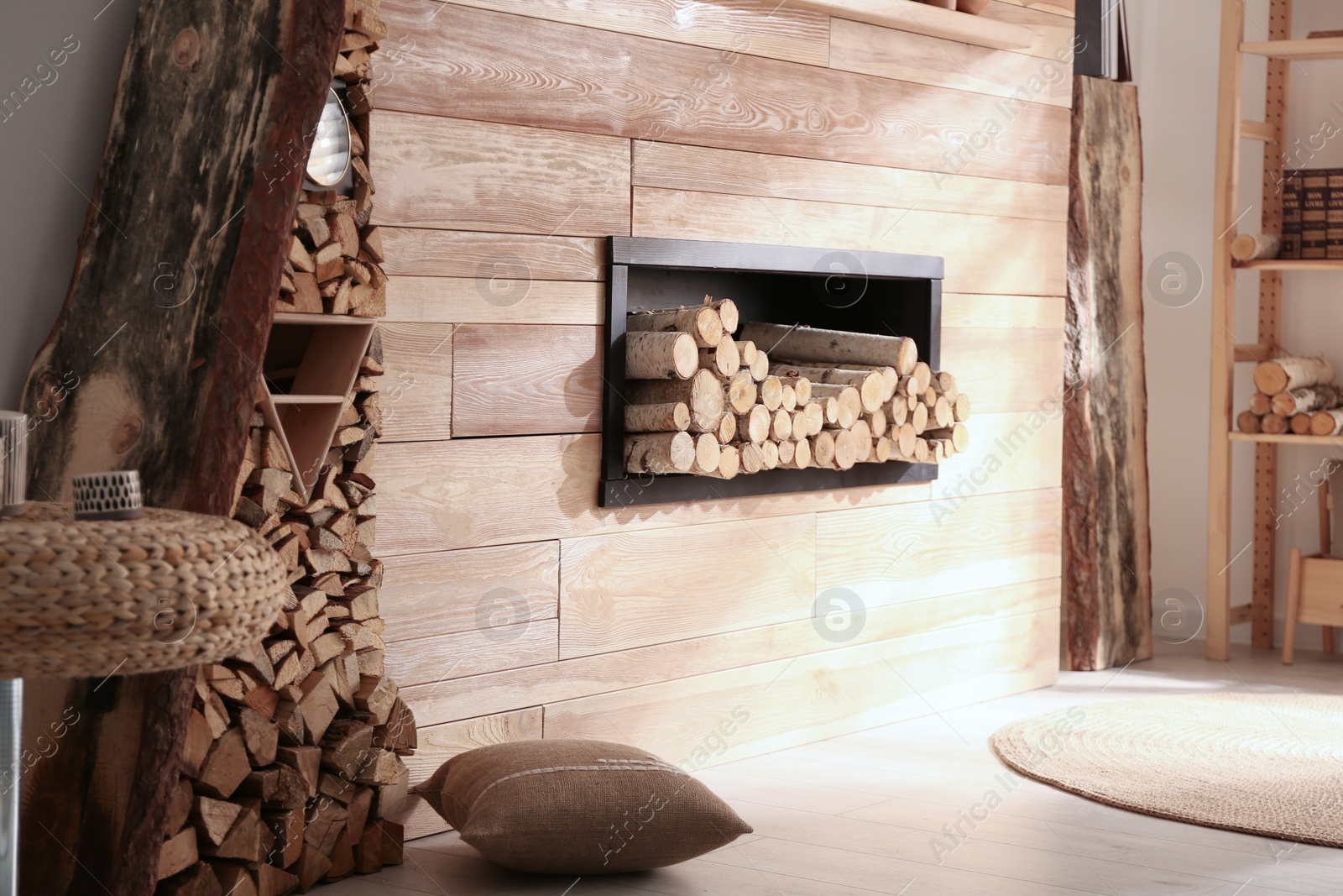 Photo of Decorative fireplace with stacked wood in cozy living room interior