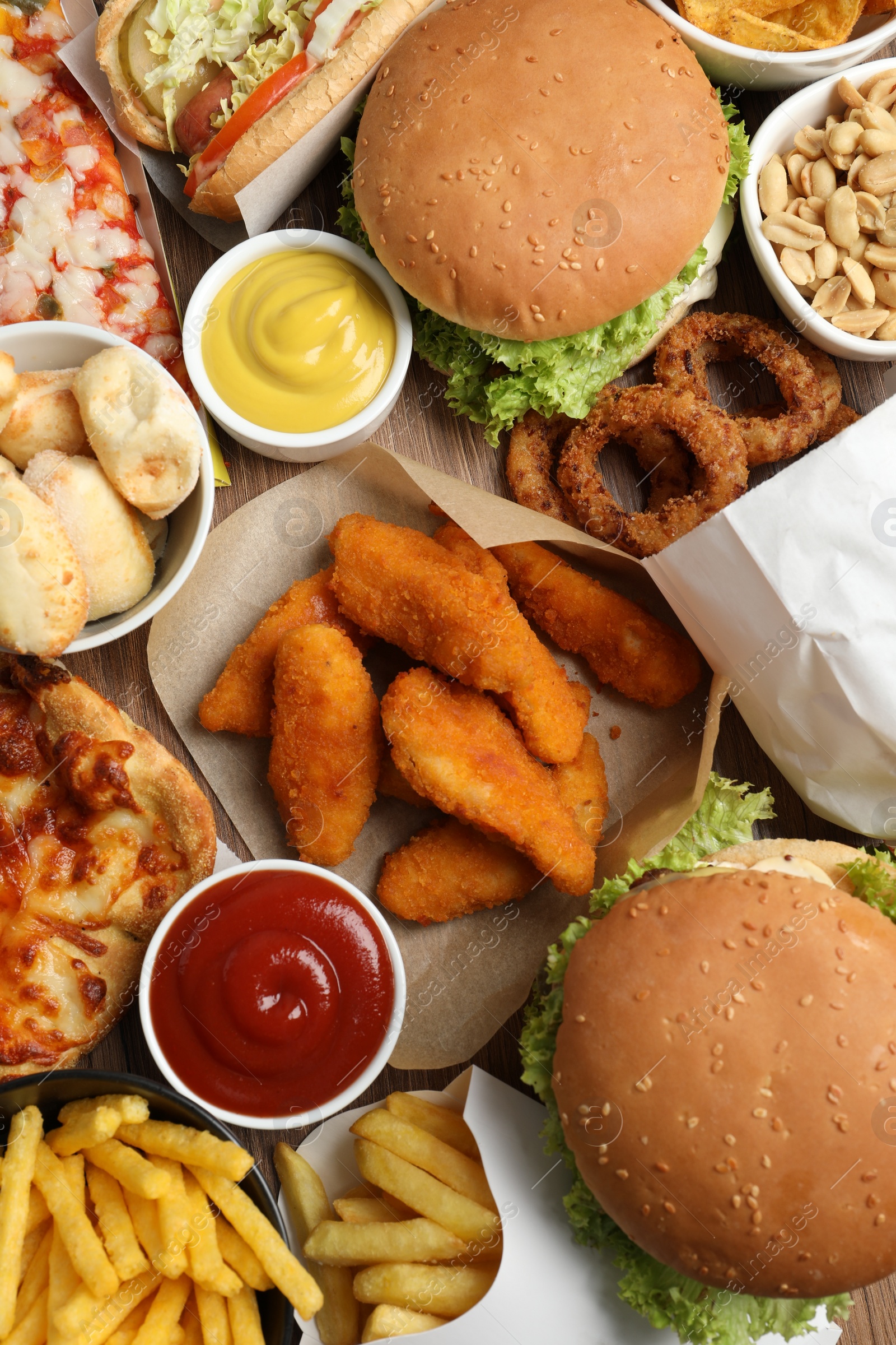 Photo of French fries, burgers and other fast food as background, top view