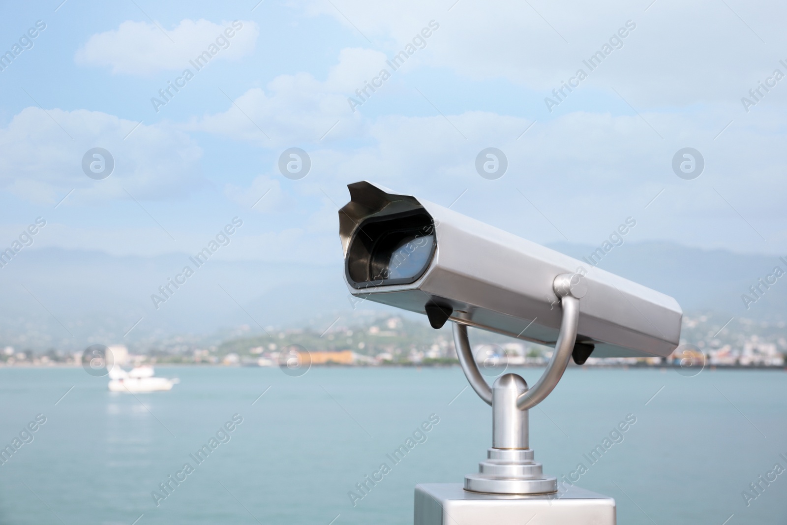 Photo of Metal tower viewer installed near sea, space for text. Mounted binoculars