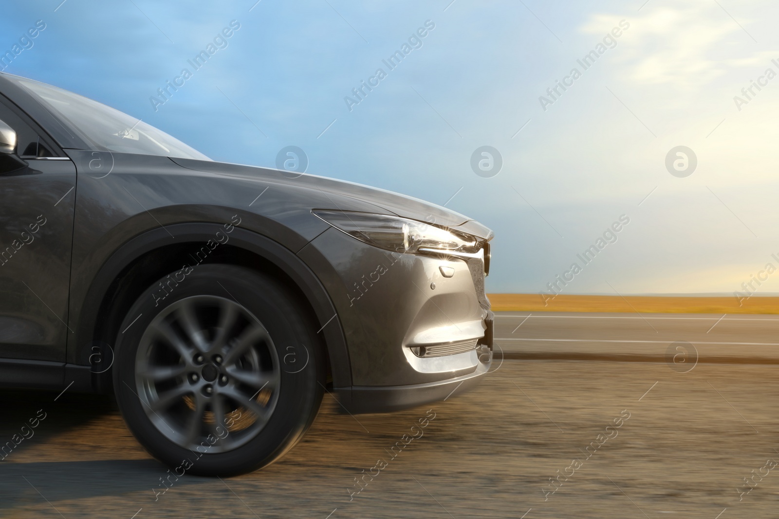 Image of Black car driving on road outdoors, motion blur effect. Space for text