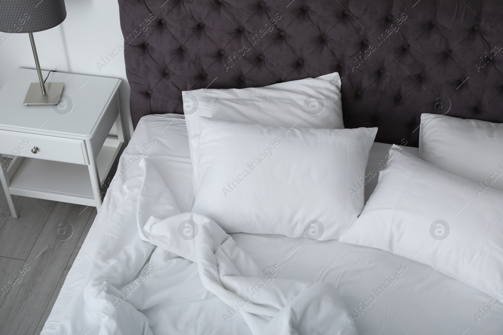 Photo of Soft white pillows on comfortable bed indoors