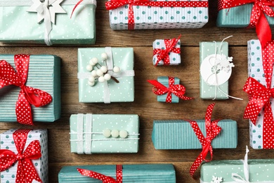 Different Christmas gift boxes on wooden background, flat lay