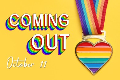 Image of National Coming Out day, October 11. Rainbow pride ribbon with heart pendant on yellow background, top view