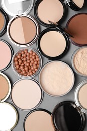 Photo of Different face powders on grey background, flat lay