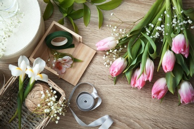 Photo of Decorator's workplace with beautiful flowers, top view