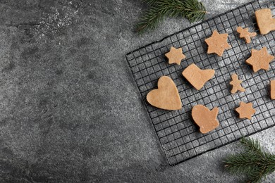 Photo of Homemade Christmas cookies. Baking rack with raw gingerbread biscuits on grey table, flat lay and space for text