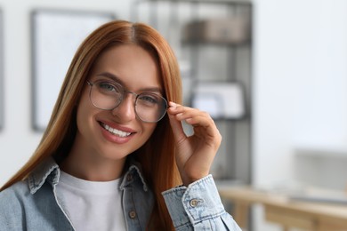 Photo of Portrait of beautiful young woman with red hair at home. Attractive lady smiling and looking into camera. Space for text