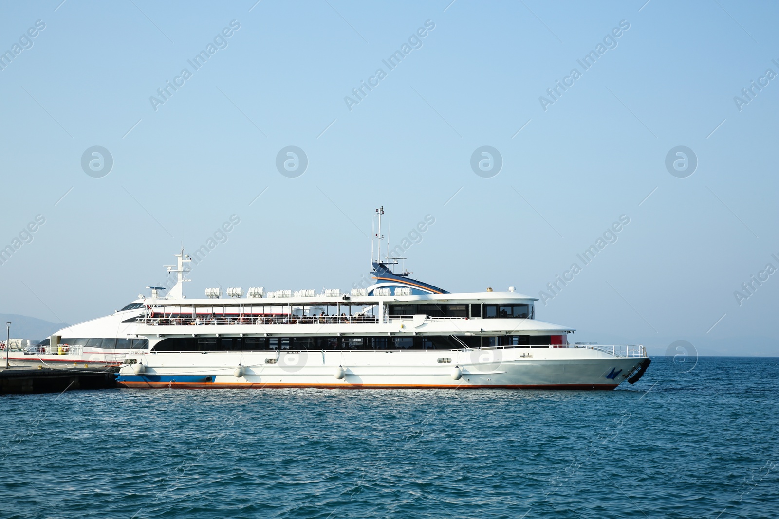 Photo of Picturesque view of ferry moored in sea port on sunny day