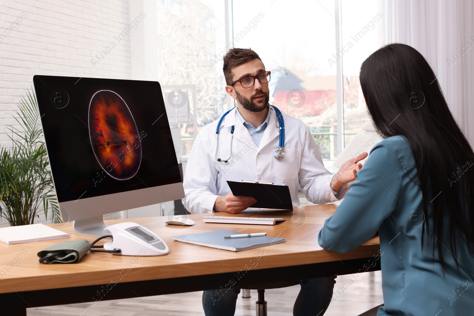 Photo of Neurologist consulting young patient at table in clinic