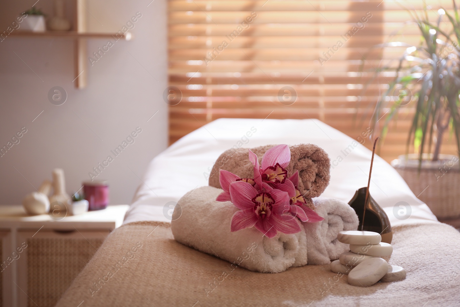 Photo of Beautiful spa accessories on massage table in room