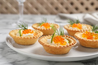 Delicious canapes with red caviar on white marble table, closeup