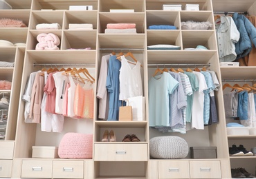 Photo of Stylish clothes, shoes and accessories in large wardrobe closet, below view