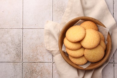 Photo of Delicious Danish butter cookies on white tiled table, top view. Space for text