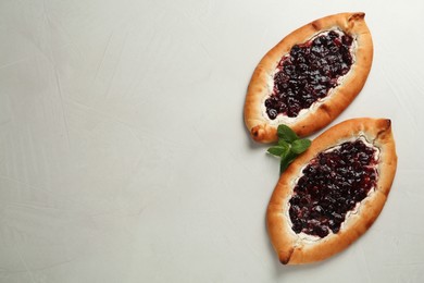 Photo of Delicious sweet cottage cheese pastry with cherry jam on light table, flat lay. Space for text