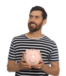 Happy man with ceramic piggy bank on white background