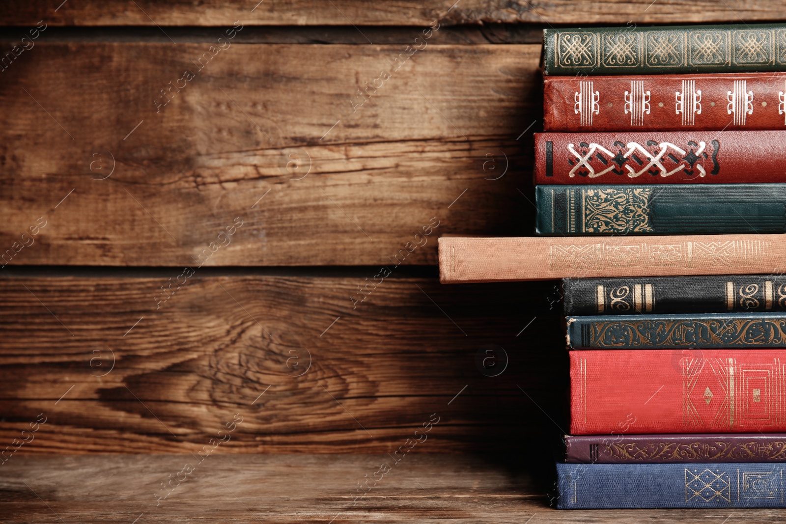 Photo of Collection of different books on table against wooden background. Space for text