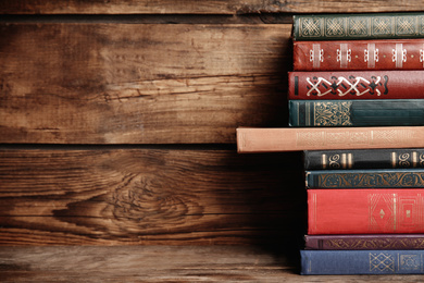 Collection of different books on table against wooden background. Space for text