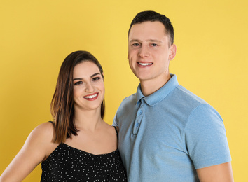 Photo of Happy young couple posing on yellow background