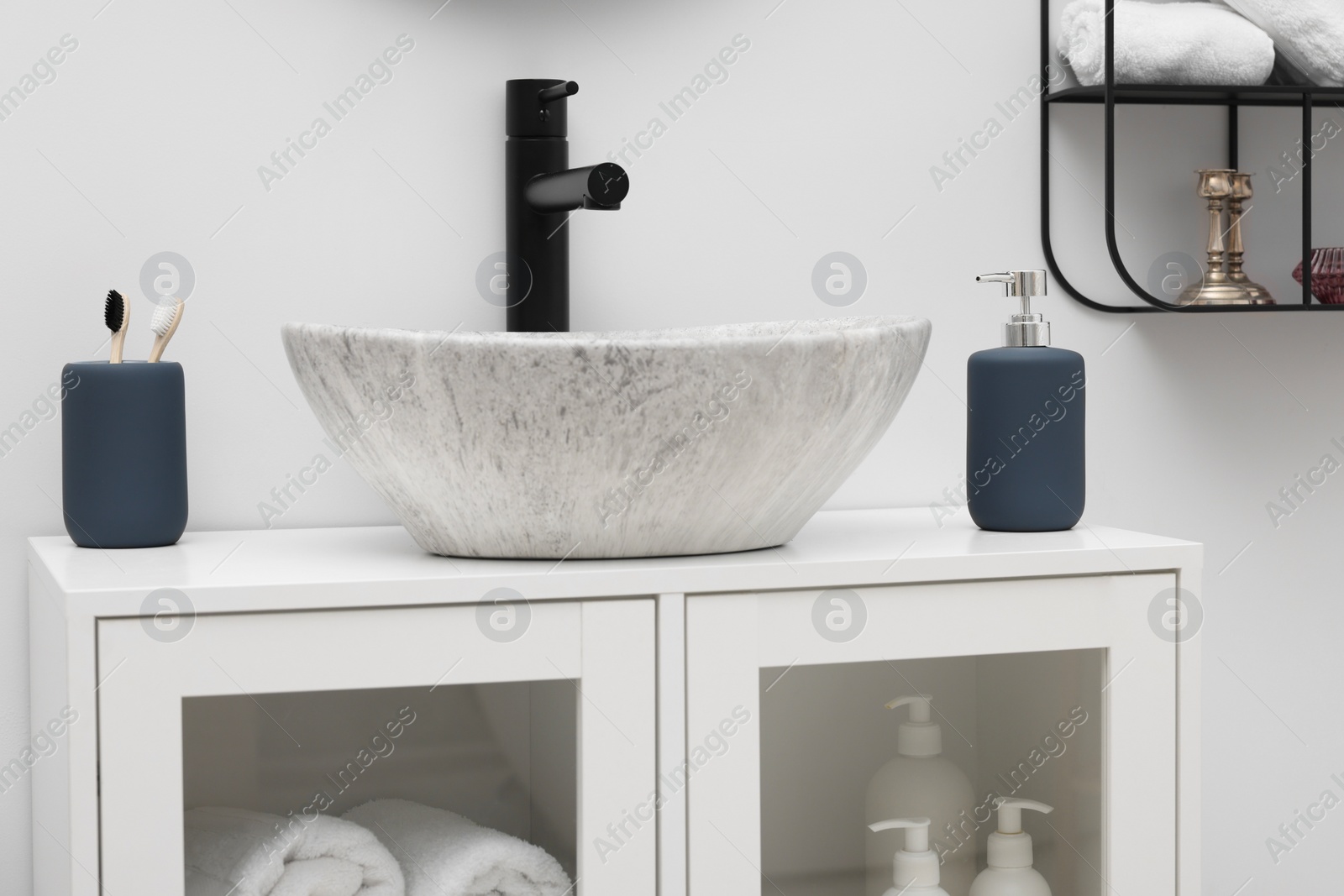 Photo of Different bath accessories and personal care products near sink on bathroom vanity