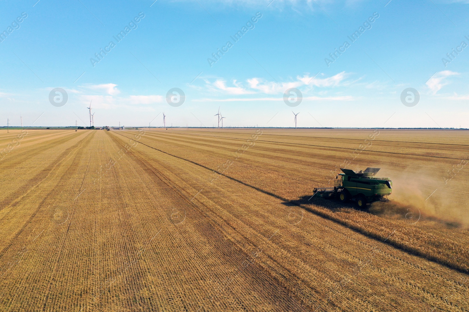 Photo of Modern combine harvester working in field on sunny day. Agriculture industry