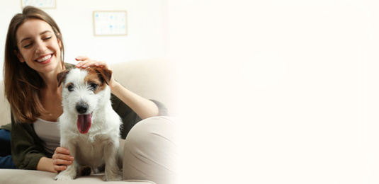 Young woman with her cute pet at home, space for text. Banner design