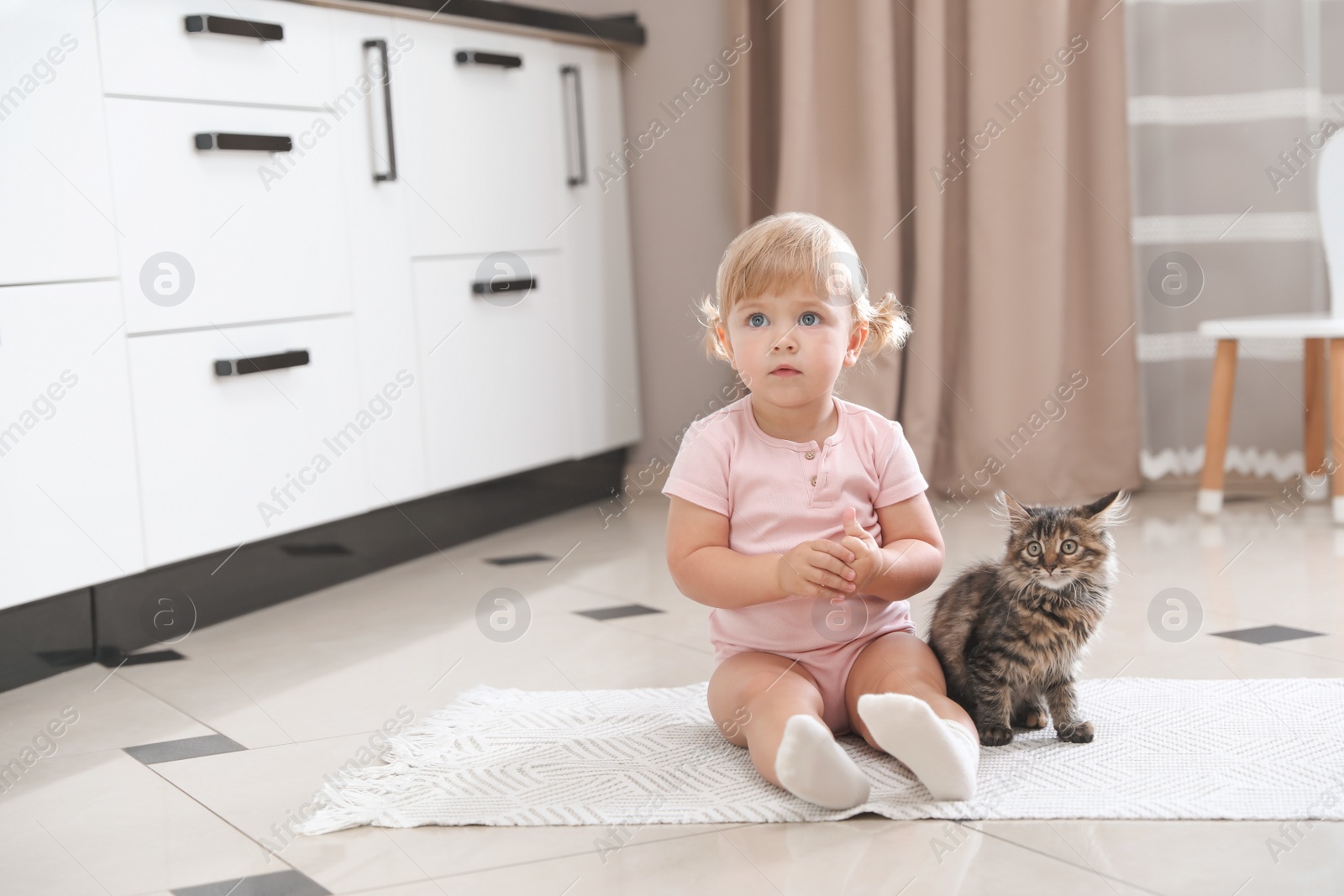 Photo of Cute little child with adorable pet on floor at home