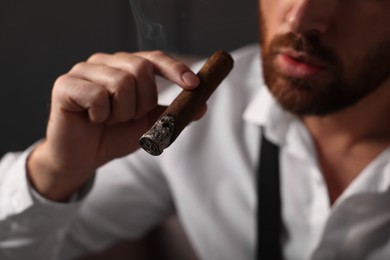 Photo of Bearded man smoking cigar indoors, closeup view