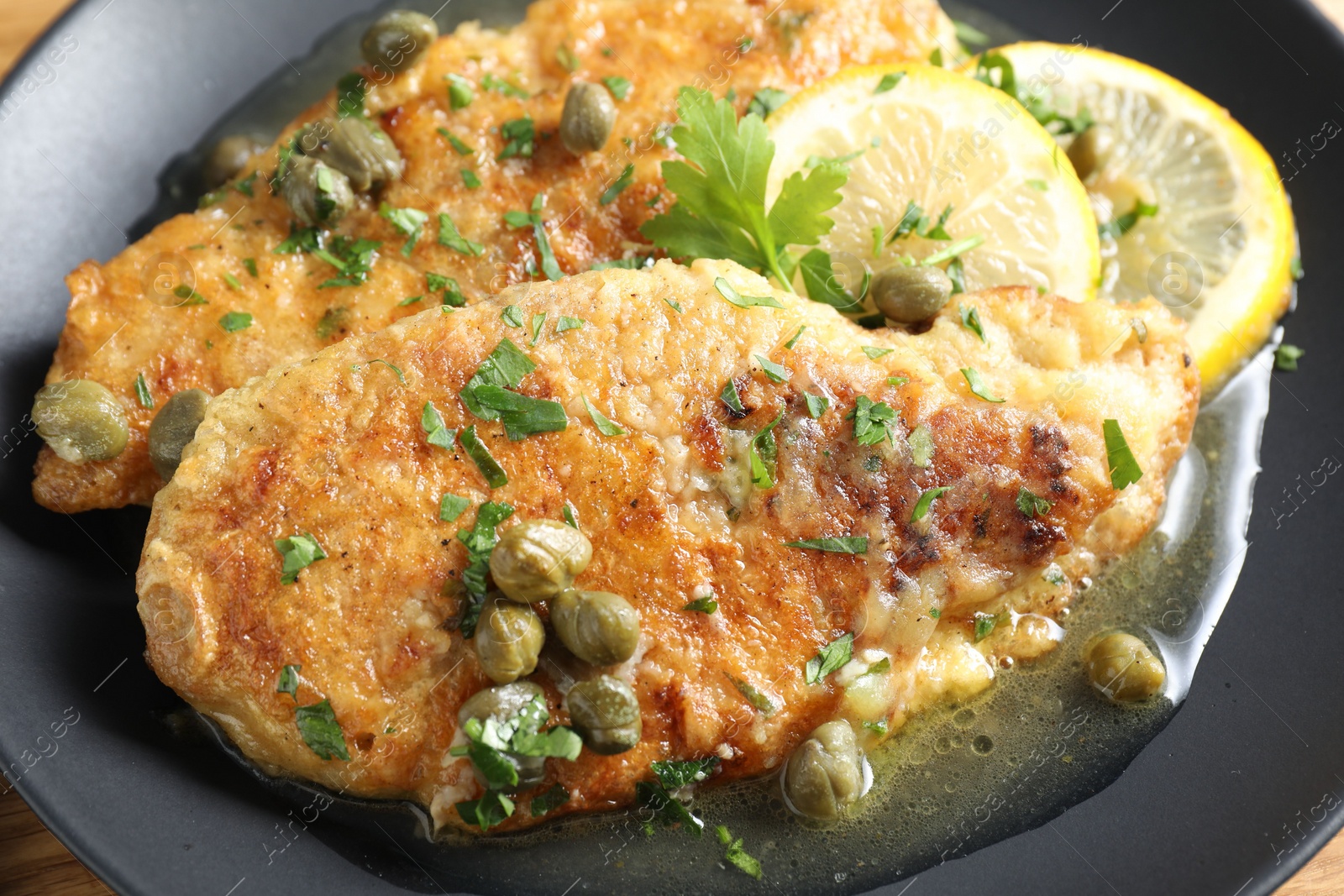 Photo of Delicious chicken piccata with herbs on table, closeup