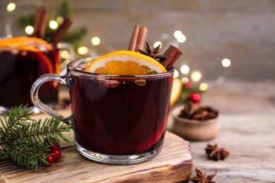 Aromatic mulled wine on wooden board, closeup
