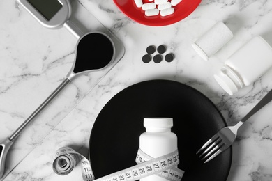 Photo of Flat lay composition with weight loss pills and scales on marble background