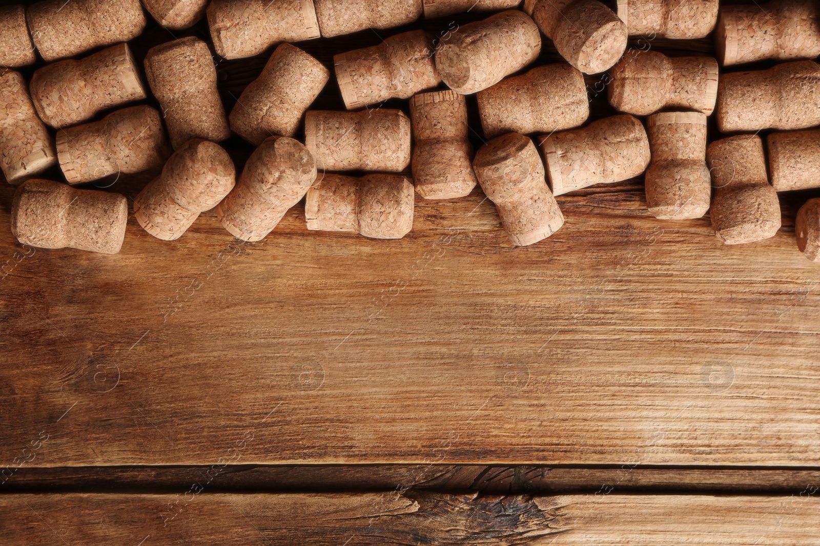 Photo of Sparkling wine bottle corks on wooden table, flat lay. Space for text