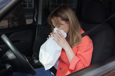 Photo of Woman with paper bag suffering from nausea in car