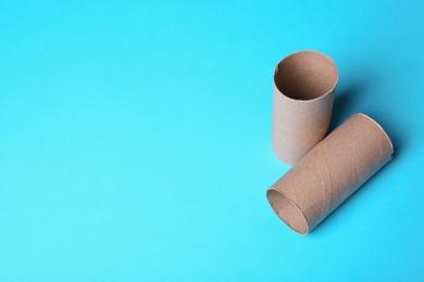 Photo of Empty toilet paper rolls and space for text on color background