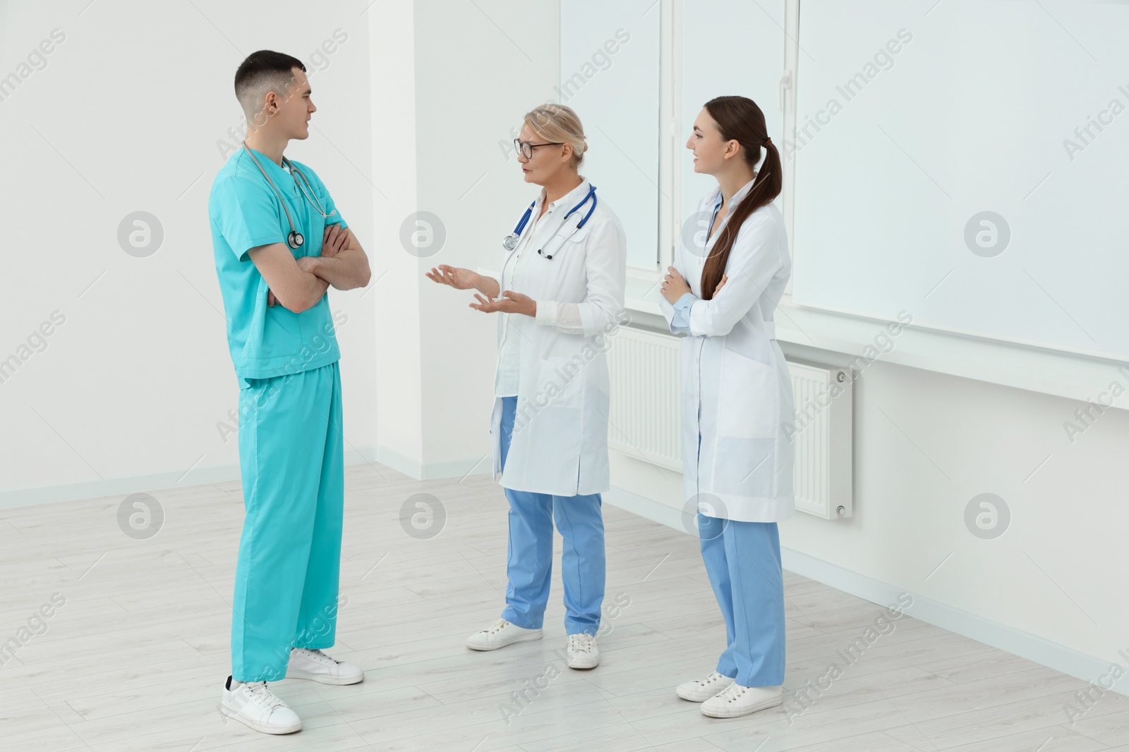 Photo of Medical doctors in uniforms having discussion in clinic