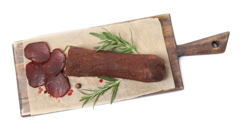 Delicious dry-cured beef basturma with rosemary and peppercorns on white background, top view
