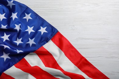 American flag on white wooden background, top view. Space for text