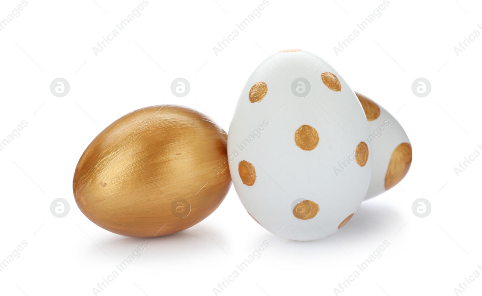 Photo of Set of traditional Easter eggs decorated with golden paint on white background