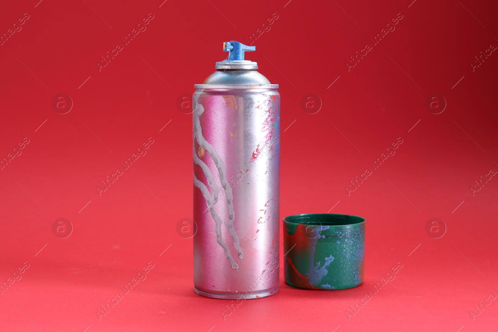 Photo of One can of bright spray paint with cap on red background