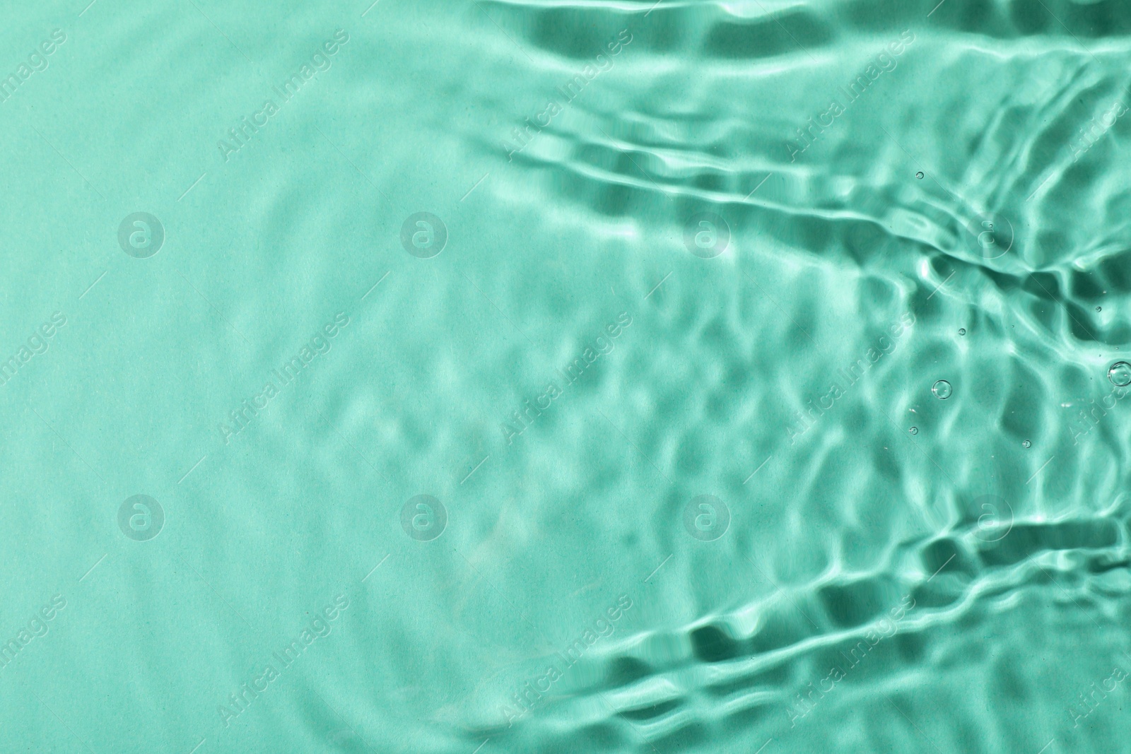 Photo of Closeup view of water with rippled surface on light blue background