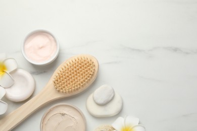 Flat lay composition with different spa products on white marble table. Space for text