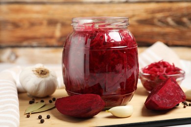 Photo of Jar with delicious pickled beetroot and spices on table, closeup