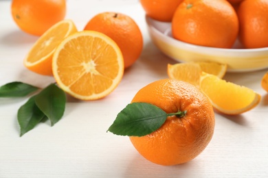 Delicious ripe oranges on white wooden table