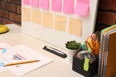 Photo of Business process planning and optimization. Workplace with colorful paper notes and other stationery on table