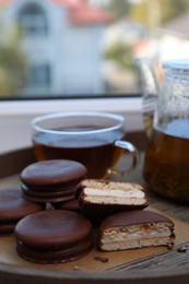 Tasty choco pies and tea on wooden tray