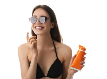 Young woman applying sun protection cream on white background