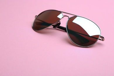 Photo of Stylish sunglasses on pink background, space for text. Fashionable accessory