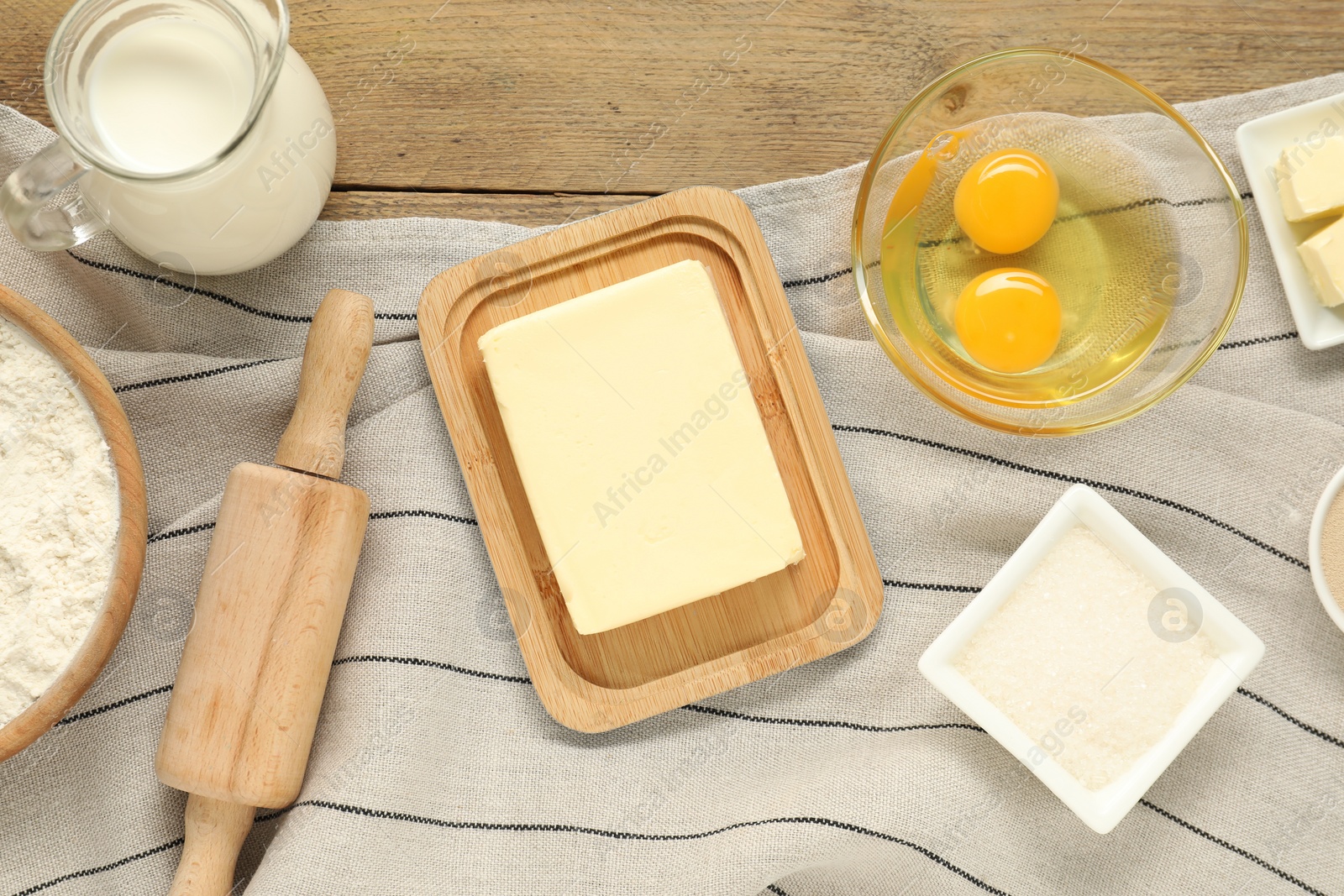 Photo of Flat lay composition with fresh butter and other products on wooden table