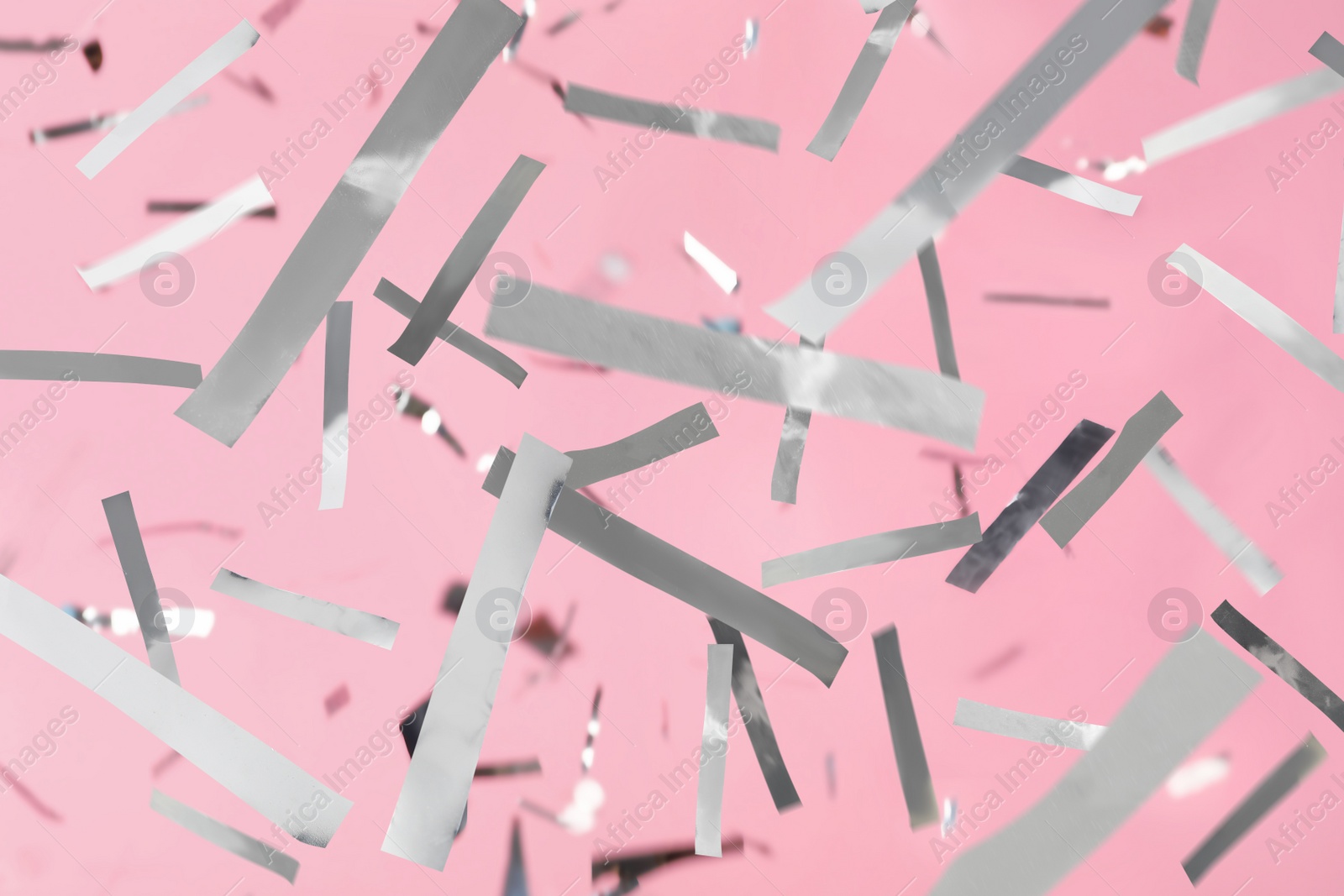 Image of Shiny silver confetti falling down on pink background