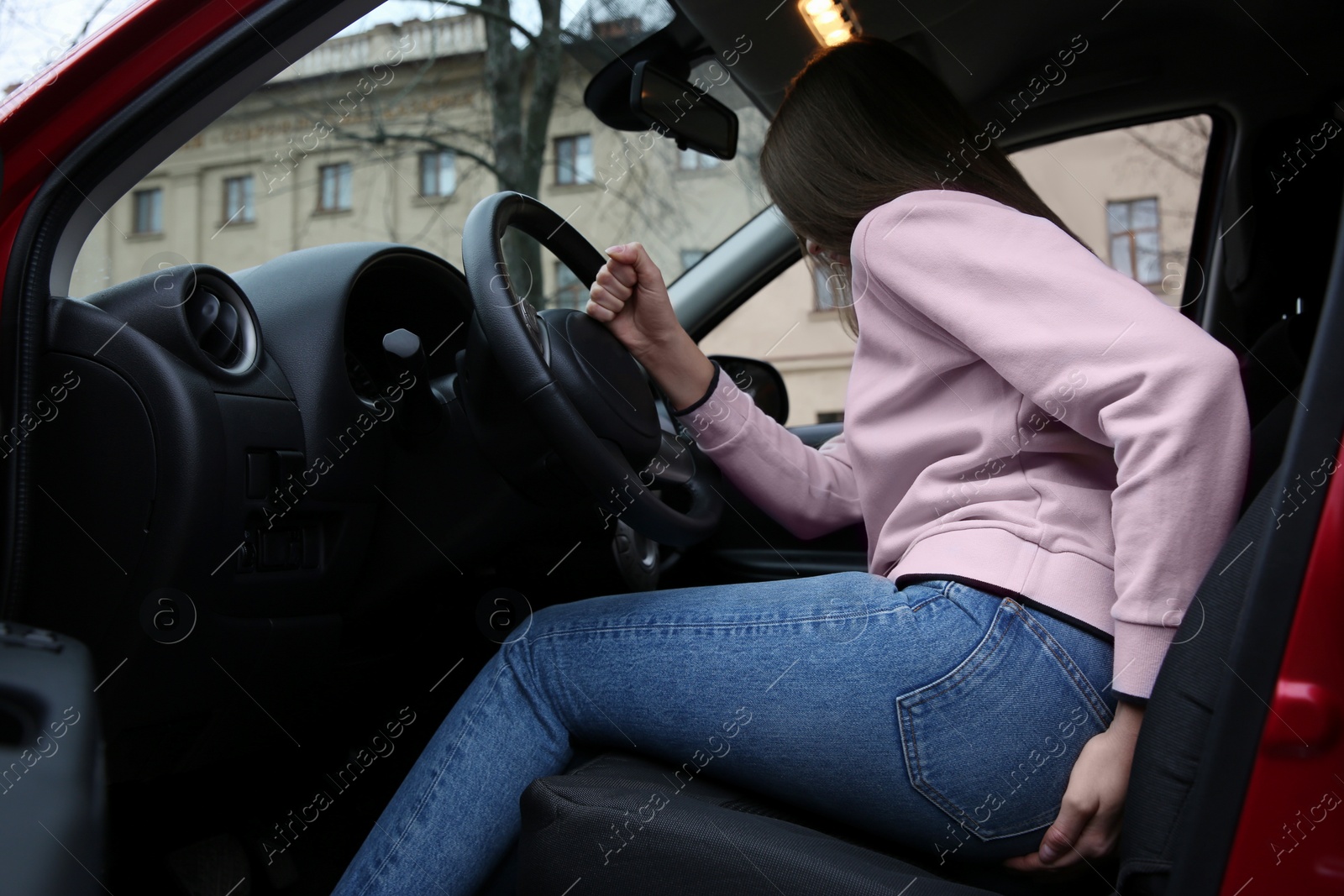 Photo of Woman suffering from hemorrhoid pain in car
