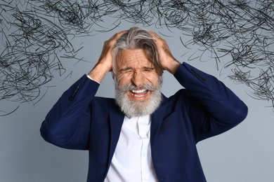 Stressed man with mess in his head on grey background